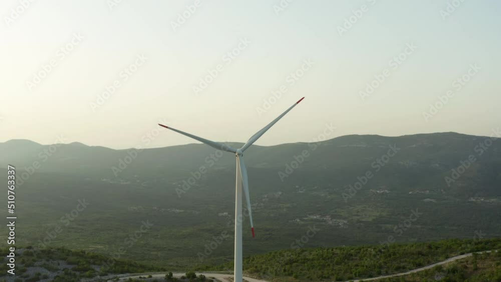 Aerial view of electricity production by windmills in the natural landscape of the mountains. Clean energy industrial and peaks with mountain ranges. Aerial view of electricity production by windmills in the natural landscape of the mountains. Clean energy industrial and peaks with mountain ranges.
