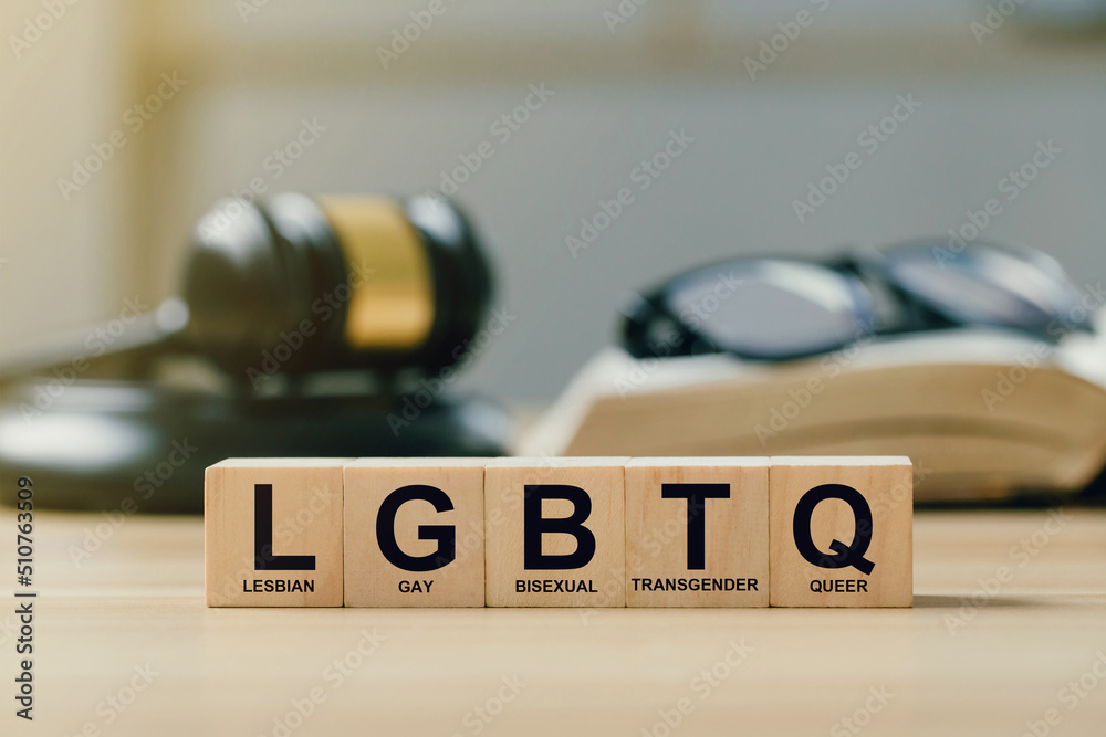 Concept of  Lgbt rights and law. wooden blocks with Text LGBTQ on Judge gavel background. symbol of law and justice in accepting same-sex couples Same-Sex Marriage, Adoption, and Social Equality.