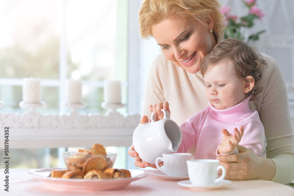 Mom and daughter eat breakfast and drink tea Mom and daughter eat breakfast and drink tea