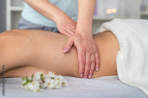 Beautiful woman lies on a table getting spa therapy procedure her back in spa salon