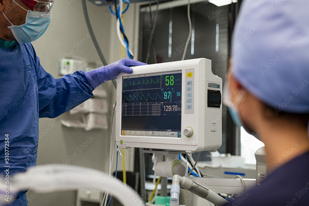 Surgeon checking heartbeat on monitor Surgeon checking heartbeat on monitor