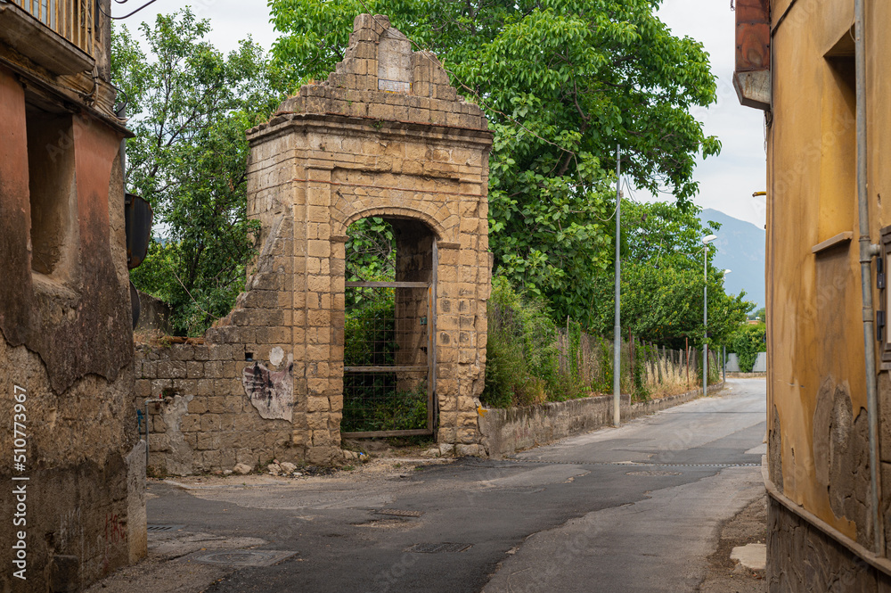 Obraz premium Narrow historic (medieval) streets of a small town in southern Italy. Old stone houses, wooden windows and doors, cobblestone road.