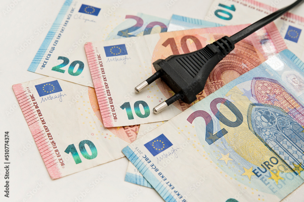Power plug on euro banknotes. Cost of electricity and expensive energy concepts. Increasing consumption, energy crisis. Inflation. Price level are getting more expensive annually. Power plug on euro banknotes. Cost of electricity and expensive energy concepts. Increasing consumption, energy crisis. Inflation. Price level are getting more expensive annually.