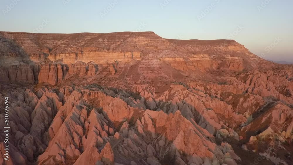 Golden hour aerial of eroded red hoodoo formations in Cappadocia Golden hour aerial of eroded red hoodoo formations in Cappadocia