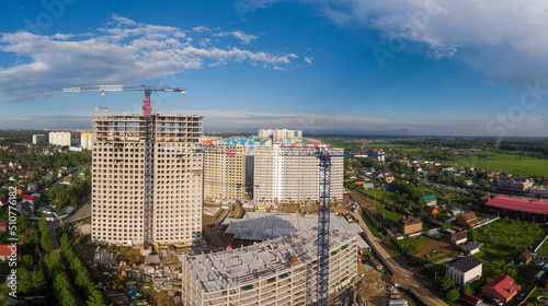 Industrial building site. skyscrapers under construction on clear blue sky background with two crane