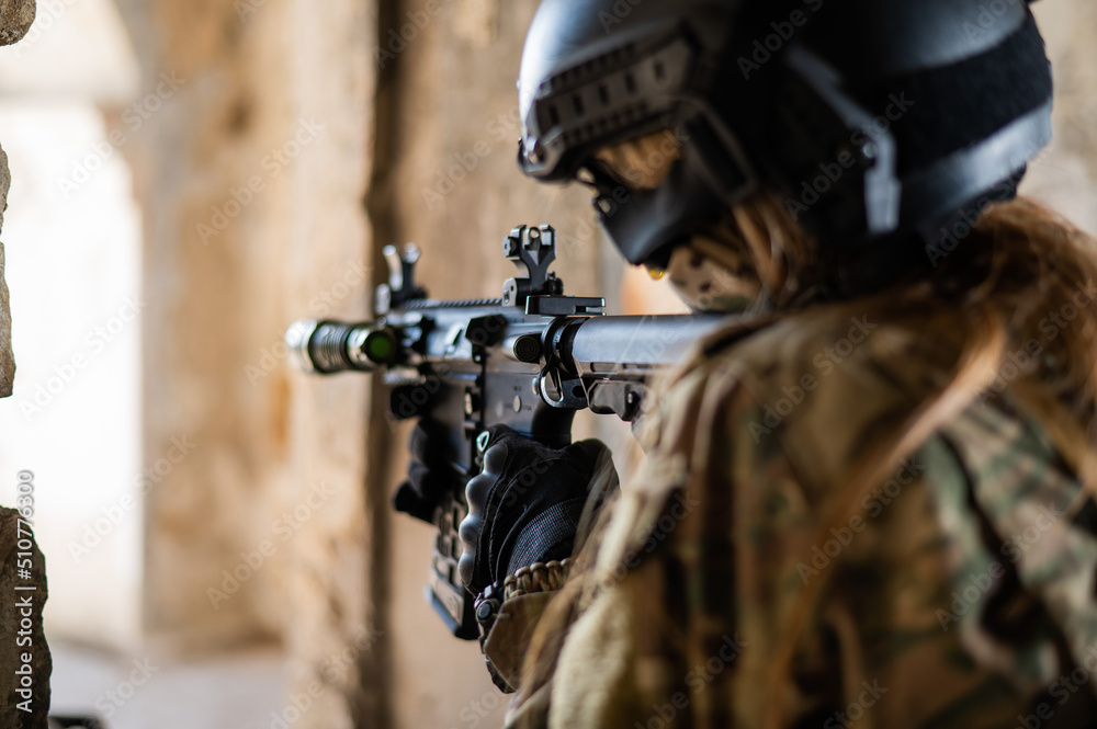 A woman in an army uniform shoots a firearm in an abandoned building. A woman in an army uniform shoots a firearm in an abandoned building.