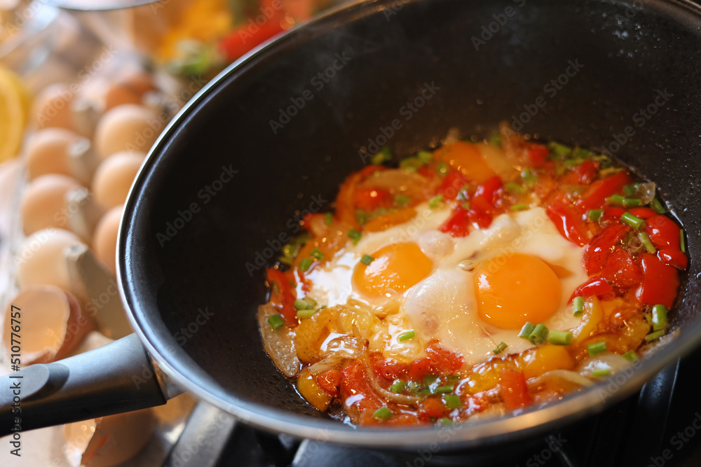Cooking tasty eggs with vegetables in frying pan, closeup Cooking tasty eggs with vegetables in frying pan, closeup