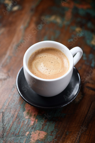 Cup of coffee on wooden background. Close up. 