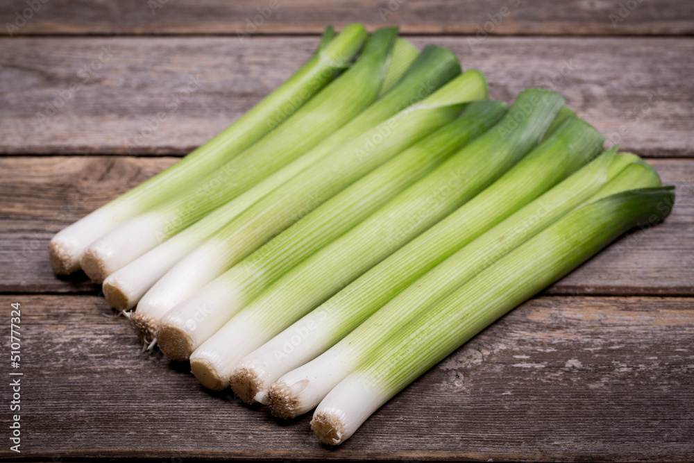 Baby leeks over old wood background
Baby leeks over old wood background