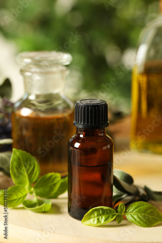 Different fresh herbs with oils on wooden table  closeup
