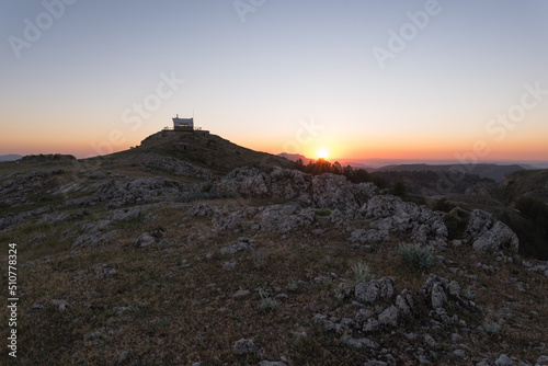 Lookout tower at mountain summit with warm light at golden hour © Ansel