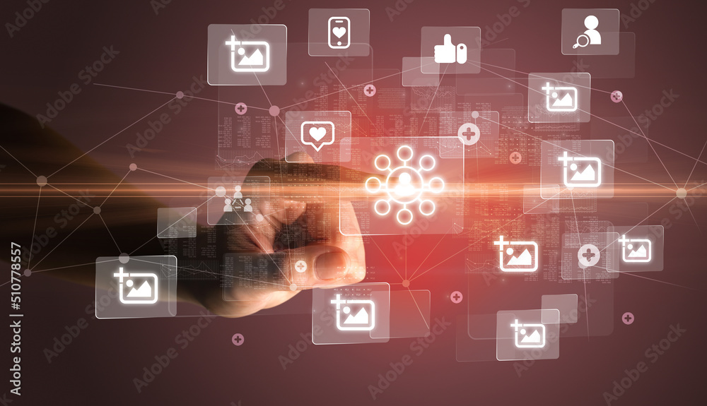 Hand pressing social media multimedia application screen with media icons on futuristic concept Hand pressing social media multimedia application screen with media icons on futuristic concept