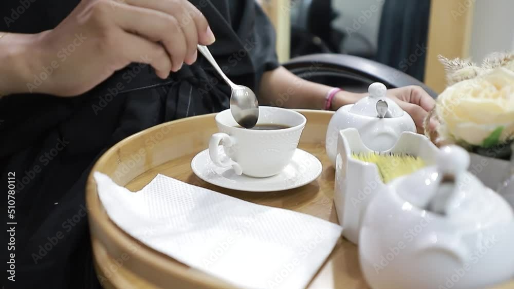 chica preparando su taza de cafe en bandeja de madera fancy., toma dolly out.