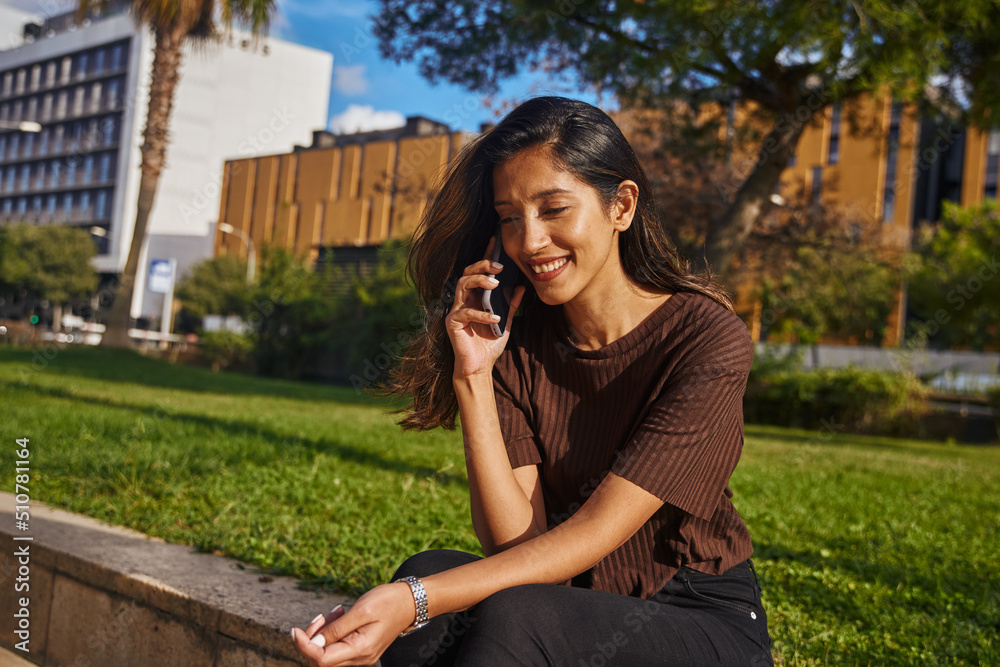 Young businesswoman sitting on boundary in park Young businesswoman sitting on boundary in park