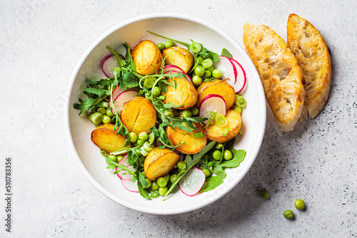 фотографія Summer potato and pea salad with arugula and radish in white bowl