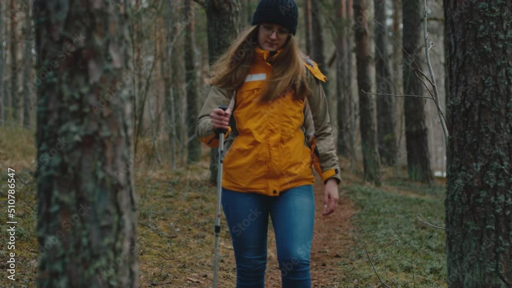Woman enjoying the tranquility in forest. She puts her hand on trunk, looks up to treetop and closes her eyes Woman enjoying the tranquility in forest. She puts her hand on trunk, looks up to treetop and closes her eyes