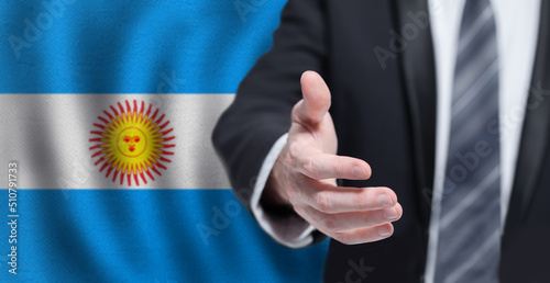 Business shaking hand to agree to joint business agreements in the future on flag of Argentina background