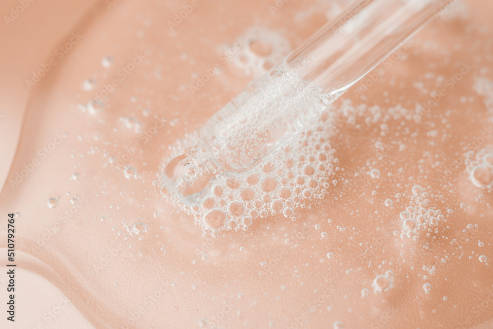 Fototapeta premium Transparent cosmetic gel in a Petri dish on a pink background. Laboratory research and development of cosmetic body care products. Close-up - the structure of the gel