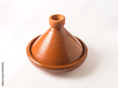 Tajin or Tagine - a traditional Moroccan clay utensil which is use to slow cook food. A terracotta Tagin photo on white background.