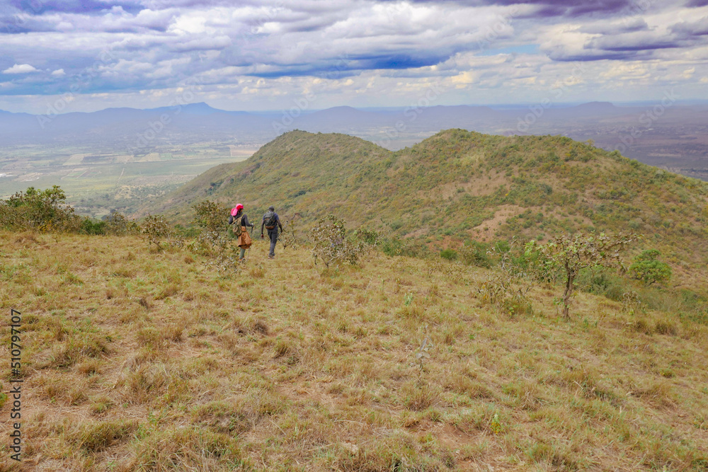 A group of hikers against a mountain background at Ole Muntus Hill in Sultan Hamud, Kenya