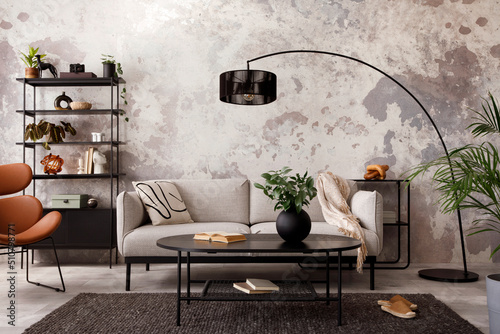The stylish compostion at living room interior with design gray sofa, armchair, black coffee table, lamp and elegant personal accessories. Loft and industrial interior. Template. . photo