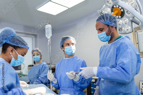 Surgical team performing surgery in modern operation theater,Team of doctors concentrating on a patient during a surgery,Team of doctors working together during a surgery in operating room, photo