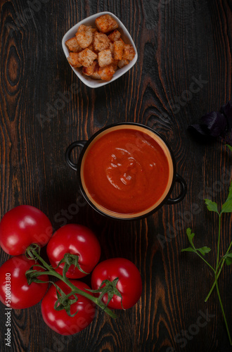 Tomato soup on wooden table  top view