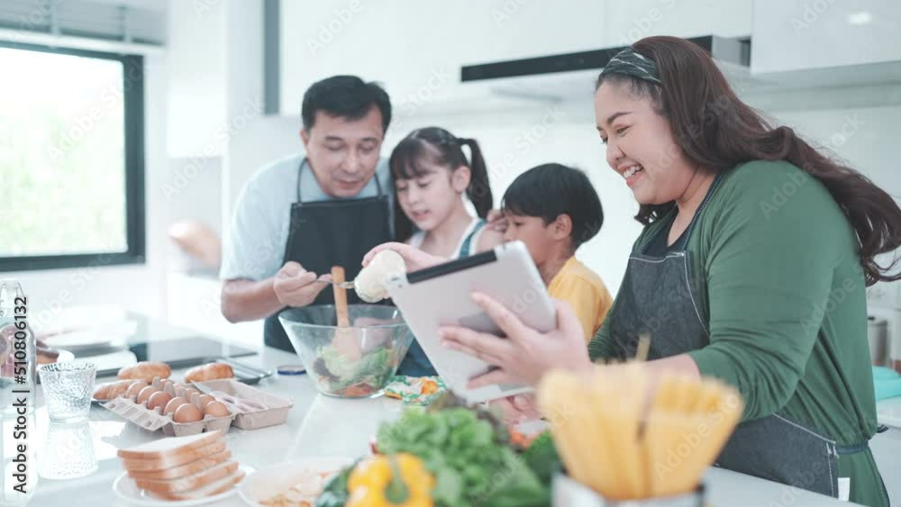 family person using digital tablet to learning to cooking a food in kitchen, child daughter with mother and father lifestyle at home together, fresh vegetable salad and meal for learn to making menu