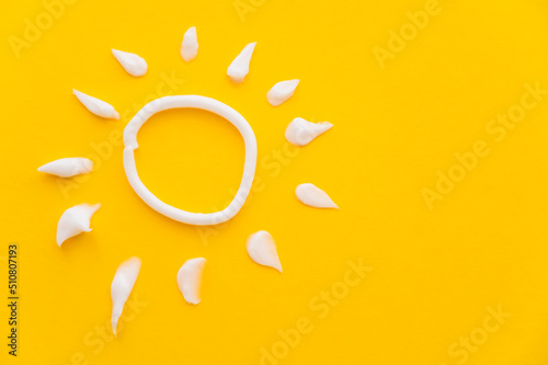 Top view of sun sign from sunscreen on yellow background. photo