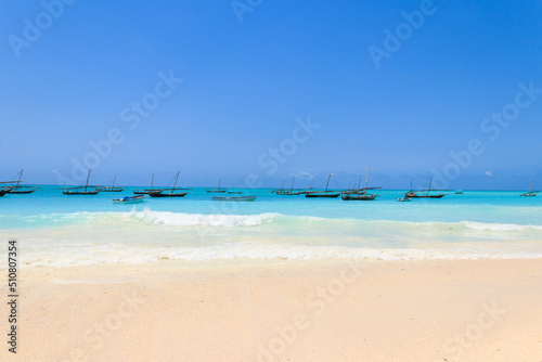 View of tropical sandy Nungwi beach and traditional wooden dhow boats in the Indian ocean on Zanzibar, Tanzania