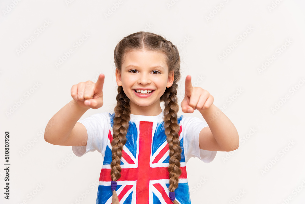 English language courses. A little girl with a big smile with the flag of Great Britain on an isolated white background. English language courses. A little girl with a big smile with the flag of Great Britain on an isolated white background.