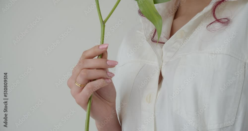 Slow mo, young hipster millennial girl smelling white lily flowers in studio, white background Slow mo, young hipster millennial girl smelling white lily flowers in studio, white background