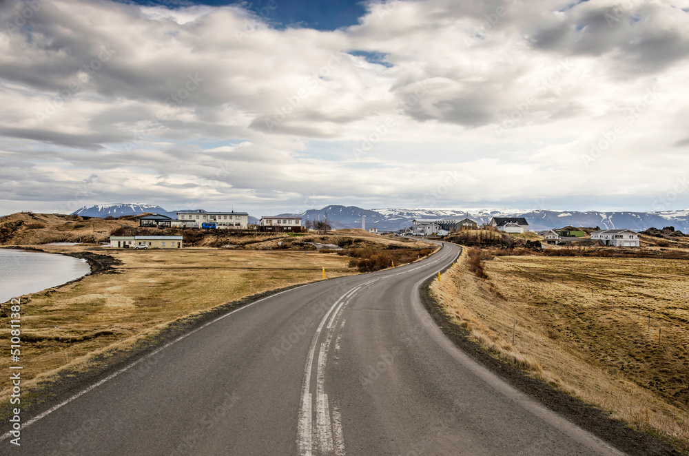 Skutustadhir, Iceland, April 29, 2022: curving asphalt road to the village on the edge of the pseudocrater area on the southern shore of lake Myvatn