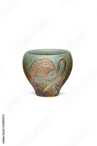 Detailed shot of a ceramic patinated printed cup in chinese style. The designer textured icing bowl with an image of a lotus leaf is isolated on the white background.