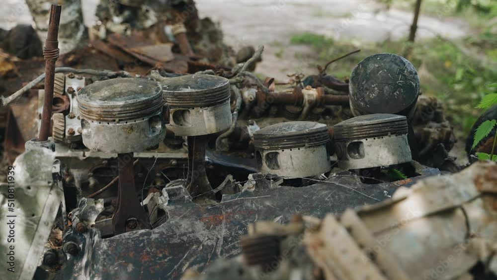 A huge old rusty airplane engine is lying in a landfill. Large pistons and other details are visible A huge old rusty airplane engine is lying in a landfill. Large pistons and other details are visible