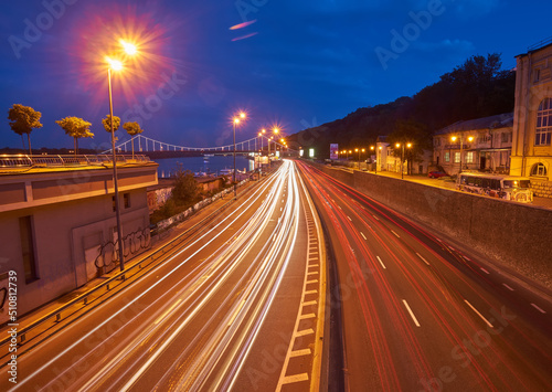 KYIV, UKRAINE, September 04, 2017: Embankment highway with tight traffic, pensot bridge in the background, evening photo