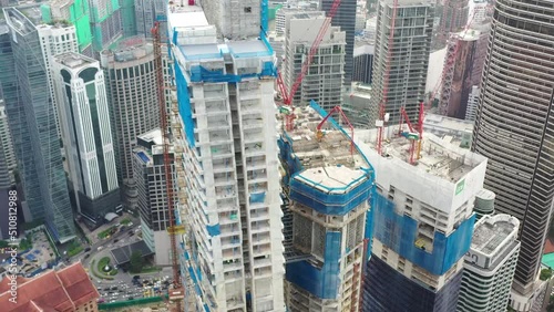 Fly around imperial lexis high rise building under construction surrounded by high density downtown cityscape, urban development in kuala lumpur, malaysia, asia. photo