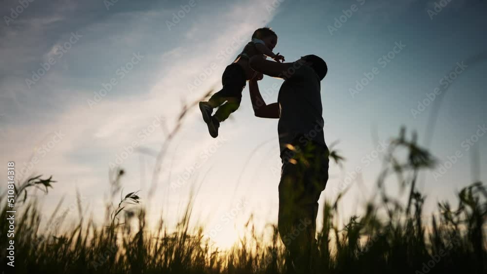 father playing with son in the park. happy family kid dream concept. father throws baby up silhouette in summer at sunset. parent and child play toss up silhouette outdoors lifestyle in the park father playing with son in the park. happy family kid dream concept. father throws baby up silhouette in summer at sunset. parent and child play toss up silhouette outdoors lifestyle in the park