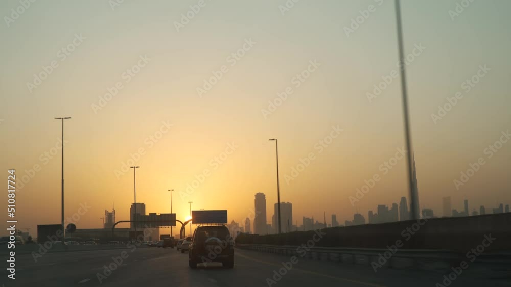 Driving a sedan car on Dubai highway at sunset Side car view driving in