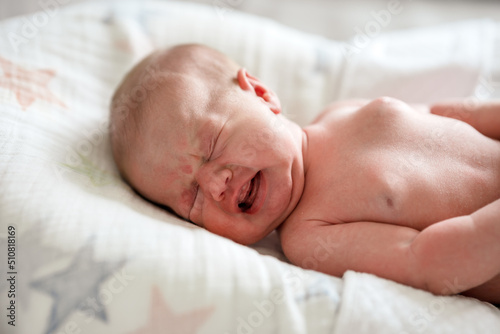 Newborn baby crying on a white background
