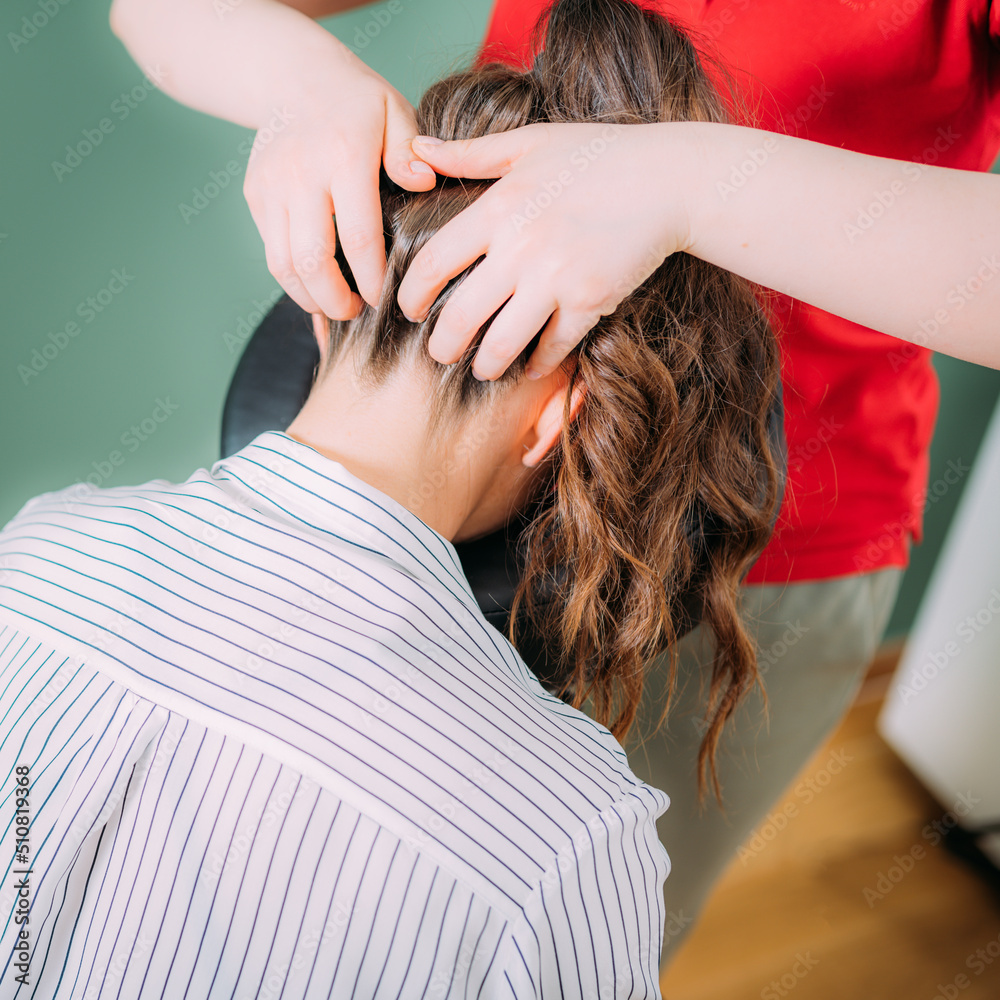 Naklejka premium Chair Massage in the Office. Female sitting in her office on a portable massage chair. Therapist massaging her neck for stress relief