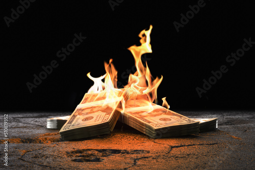 Closeup heap of Dollar bills burning with orange fire against black background. 3d render photo