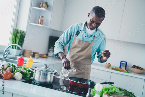 Photo of positive satisfied person enjoy cooking free time weekend kitchen house indoors