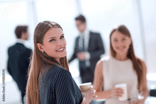 young businesswoman with a glass of coffee standing in the office