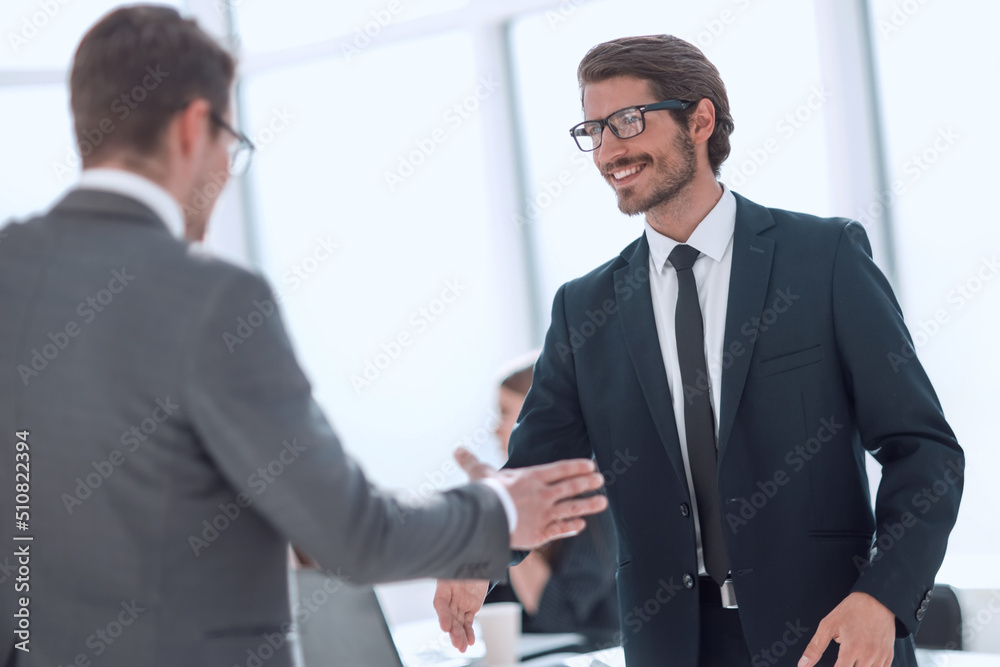 smiling business people holding out their hands for a handshake smiling business people holding out their hands for a handshake