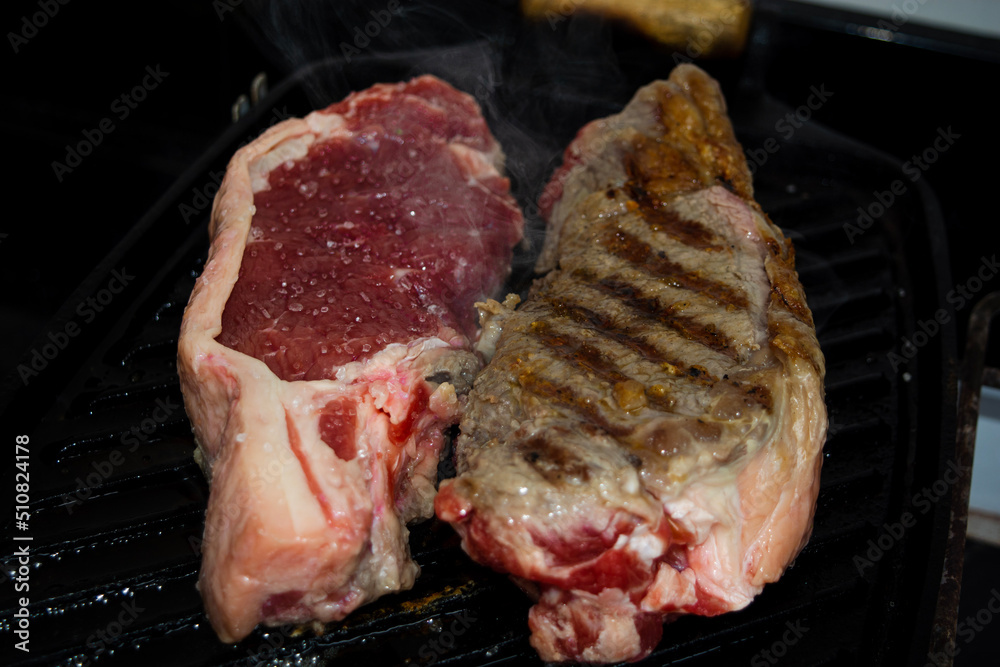 two sirloin steaks being grilled on iron cast