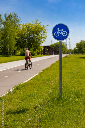a sign indicating a cycle path on which a cyclist rides