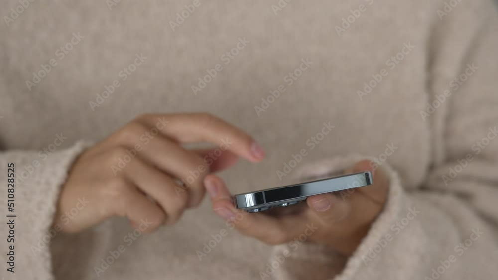 Front view. Woman holding in hands and using smartphone, typing message and browsing internet. Close up. Front view. Woman holding in hands and using smartphone, typing message and browsing internet. Close up.
