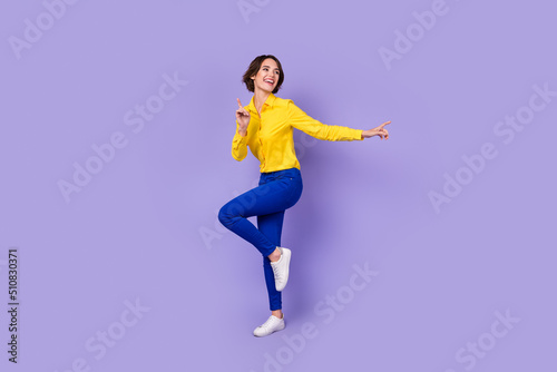 Full size photo of funny millennial lady dance look empty space wear smart casual isolated on violet background © deagreez