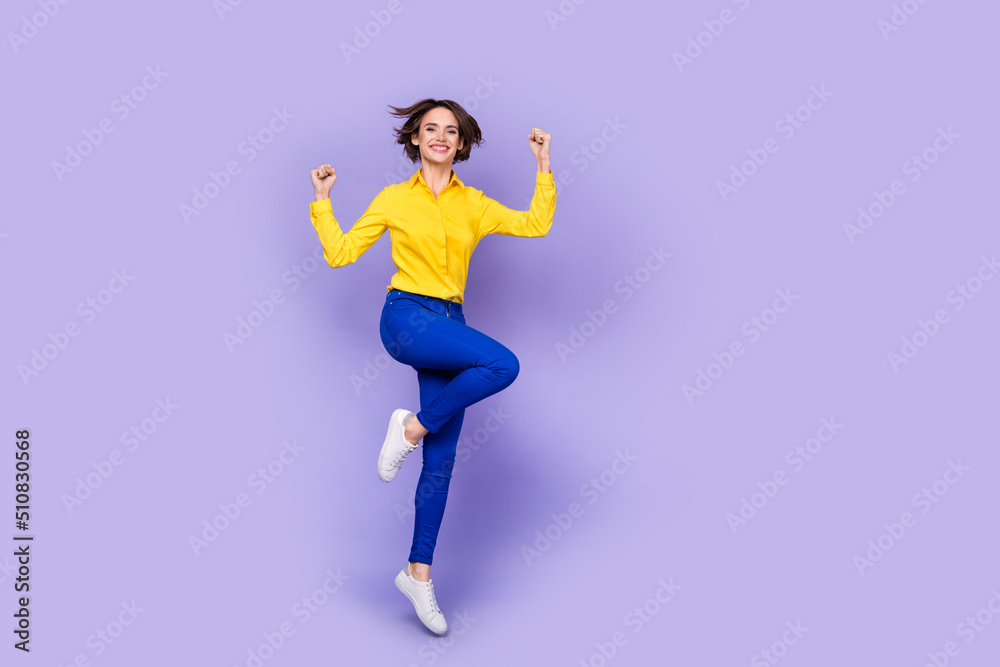 Full body photo of hooray young brunette lady jump yell wear shirt trousers sneakers isolated on purple background